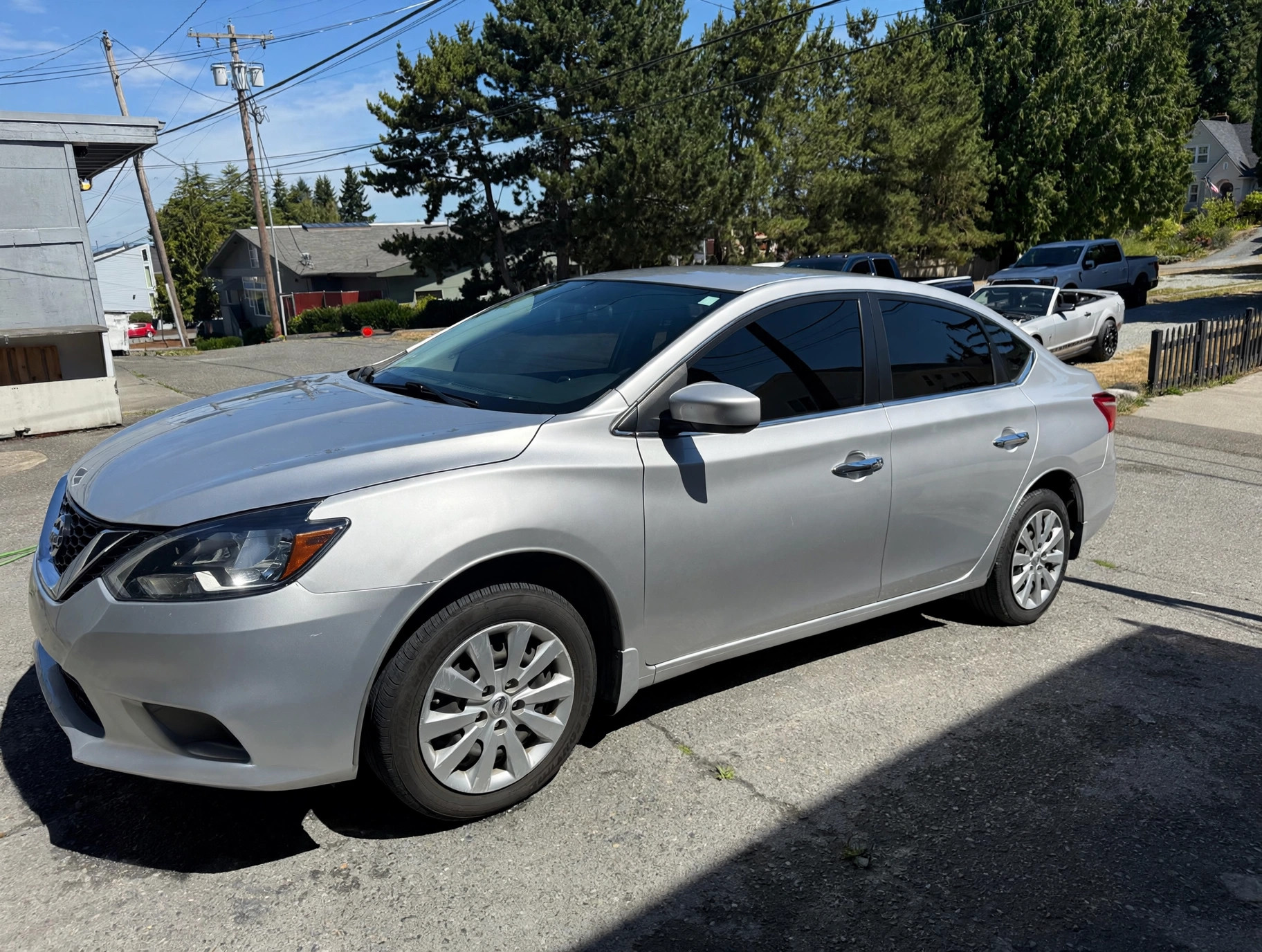 Finished silver Nissan Sentra after rear quarter repair and paint / Nissan Sentra plateado terminado después de reparar y pintar el panel lateral trasero