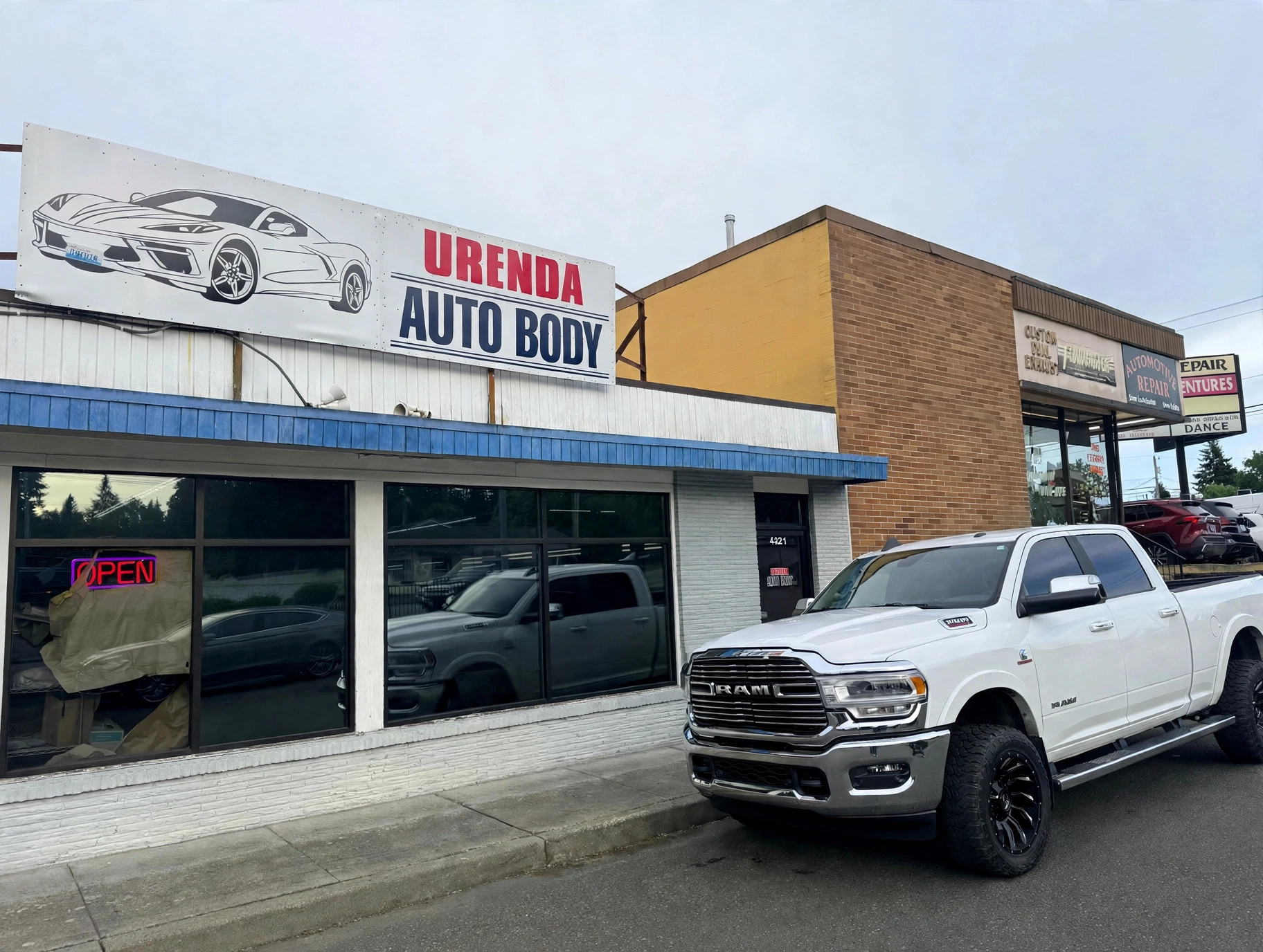 Urenda Auto Body storefront in Everett with the shop sign and a white RAM truck parked outside / Fachada de Urenda Auto Body en Everett con el letrero del taller y una camioneta RAM blanca estacionada afuera